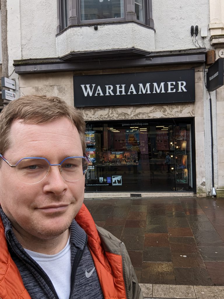 A man (Totally handsome) stands in front of a warhammer store in Cardiff