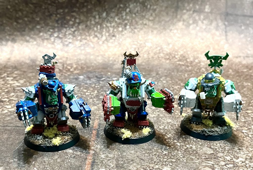 Three Ork meganobz painted to look like sports mascots