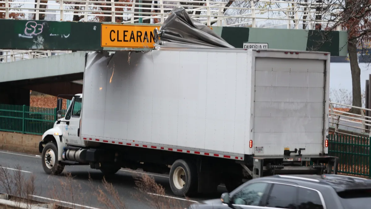 A truck driven by an idiot stuck under a bridge