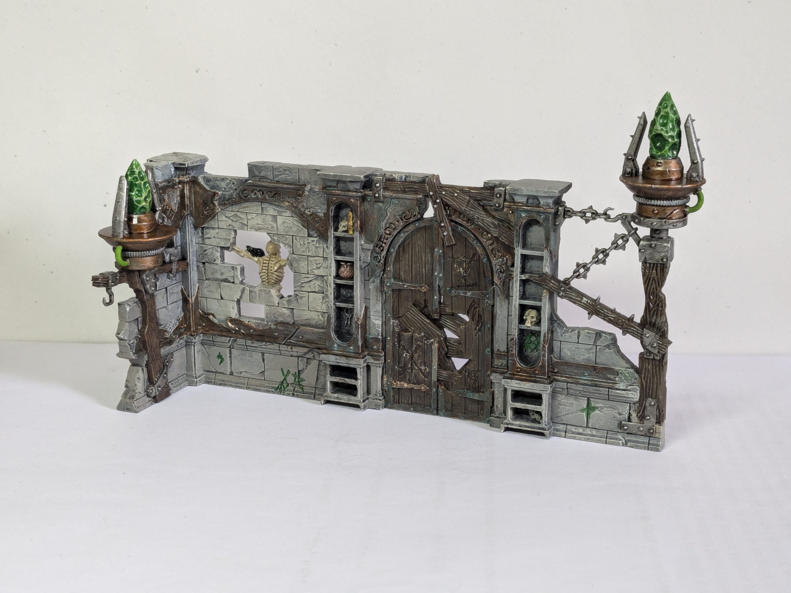 Terrain from Spearhead: Fire and Jade, featuring Skaven graffiti and warpstone braziers. Credit: Roxin