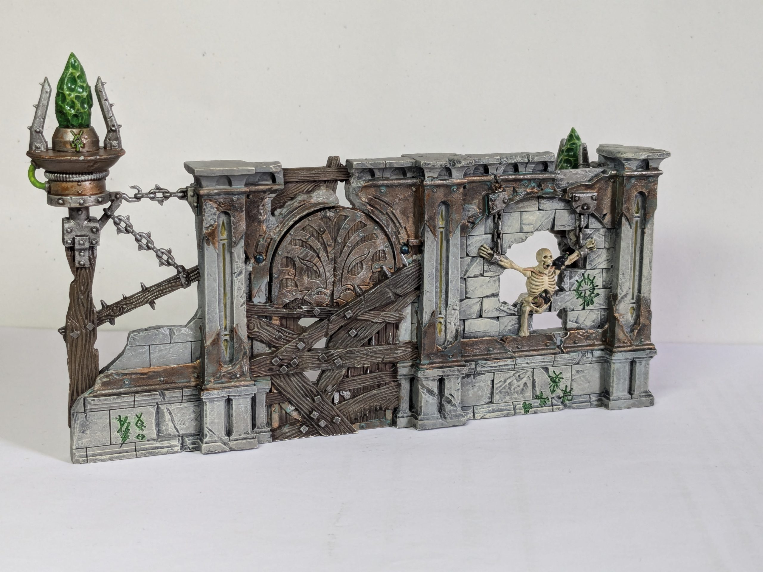 Terrain from Spearhead: Fire and Jade, featuring Skaven graffiti and warpstone braziers. Credit: Roxin